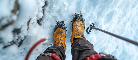 Photo sur Plexiglas Ama Dablam Professional image of climber's feet in crampons and using trekking poles, seen from above.