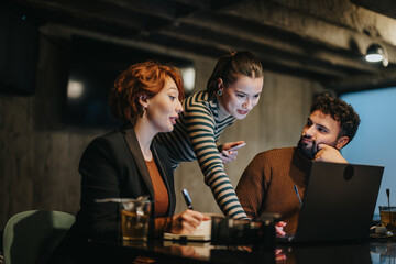 Business team working late, discussing project details, financial analysis, and market expansion strategies for profit growth and business success.