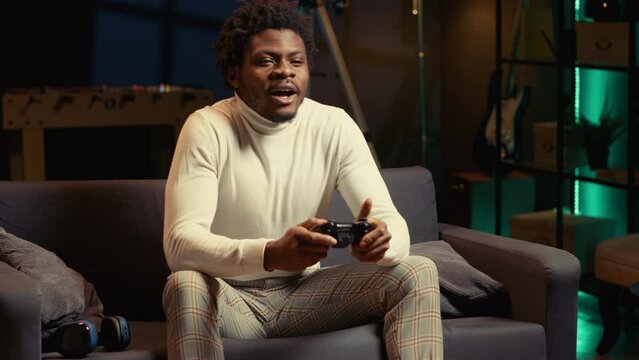 Man arriving in gaming room, ready to play videogame on console with his friends. Gamer using joypad controller to engage in multiplayer games with internet teammates, relaxing at home