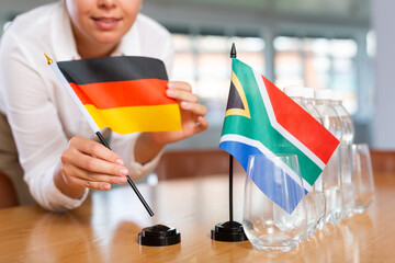 Little flag of South Africa on table with bottles of water and flag of Germany put next to it by...