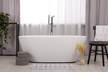 Stylish bathroom interior with soft bath mat and tub - obrazy, fototapety, plakaty