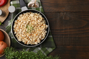 Fried ground meat in frying pan and products on wooden table, flat lay. Space for text