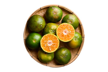 Green tangerine orange fruit in bamboo basket, top view