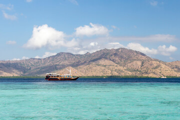 Panorama view of beaches and tourist boat sailing in Taka Makasar Island, Flores Island, Indonesia. © Yusnizam Yusof