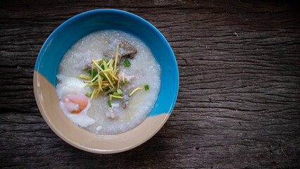 Close up Rice porridge ,congee with minced pork and ginger in white and blue bowl,Rice soup concept, on the wooden table