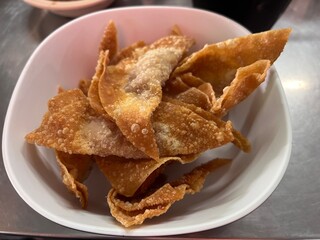 Traditional deep fried wonton filled in with marinated pork serving on the plate. Famous side dish menu in Asian noodle restaurant.