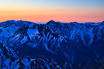 冠雪の夕焼けの北アルプスの稜線