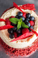 Red Velvet Cake with Mascarpone Cream Cheese, decorated with fresh raspberries, blueberries, and coral tuile. 
