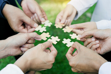 group of business people assembling jigsaw puzzle. The concept of cooperation, teamwork, help and...