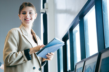 Attractive, happy, smiling Caucasian businesswoman is drafting, sketching or having an inspiration, ideas and vision while work on tablet. Portrait of Female professional smart designer or architect.