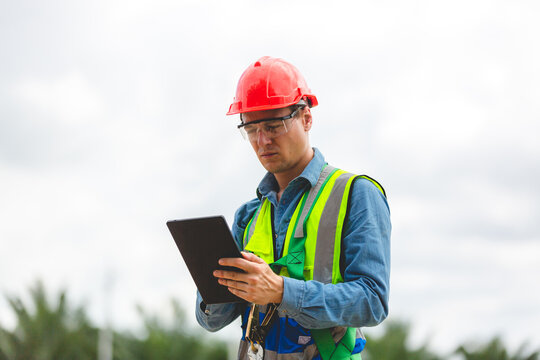 Professional engineer or technician inspector using tablet to working and checking to maintenance at solar panels farm system, Renewable energy and alternative sustainable innovation, sunlight power.