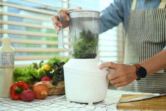 Senior man making vegetable smoothie with fresh vegetables in a blender. Healthy eating lifestyle concept - Powered by Adobe