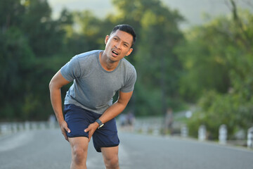 40 years old athlete man having a knee injury during running workout, training. Health care concept.