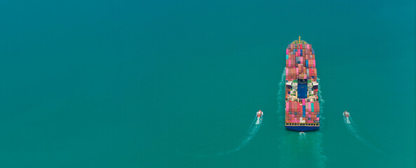 Aerial side view of cargo ship carrying container and running for export goods from cargo yard port...