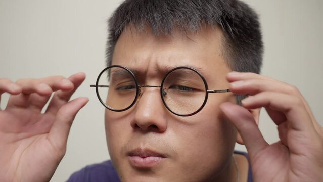 Young asian man testing his eyesight with a pair of eyeglasses, Portrait