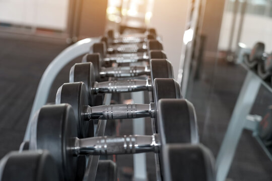 Rows of chrome metal dumbbells in the gym of modern dumbbells equipment in the sport