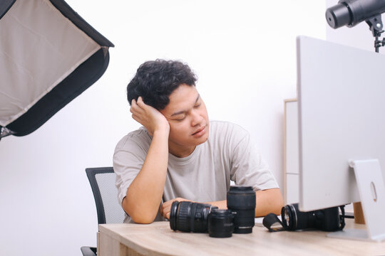Tired photographer working at his workplace.