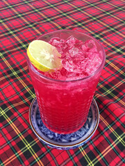 Iced red soda with lime on the table is a refreshing drinking menu.