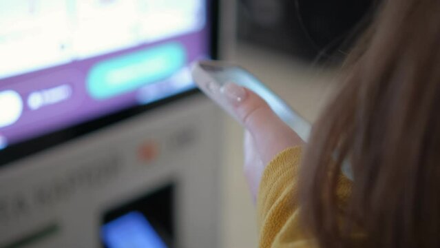 Woman choosing food via self-service machine at fast food restaurant. Girl using touch terminal im makes a quick order through the self-service. Person swipes the screen making an order.4K