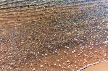 Soft wave of the sea on the sandy beach.