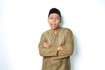 thoughtful asian muslim man wearing islamic koko clothes folded arm thinking with looking at camera...