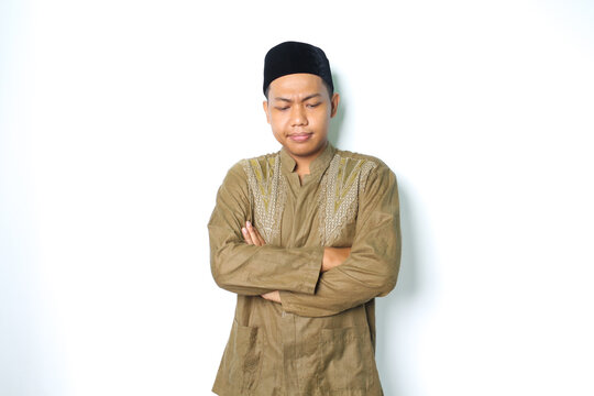 thoughtful asian muslim man wearing islamic koko clothes folded arm thinking isolated on white background