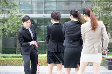 Business people having a tug of war fight.