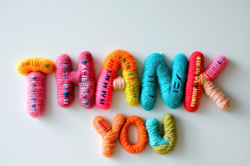 The words Thank you in colorful felt letters on a white background