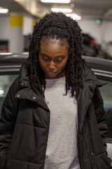 This evocative image features a young Black woman in contemplation, her gaze cast downward in a...