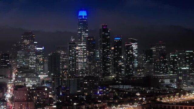 San Francisco night evening buildings downtown skyline. Skyscrapers finance district. Aerial flight over San Francisco city downtown illuminated at night. Night traffic aerial panorama 4K drone shot