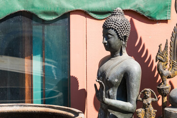 Bangkok, Thailand - December, 18, 2023 : Buddha statue next to the shop selling Buddha statues on the road beside at Bangkok, Thailand.