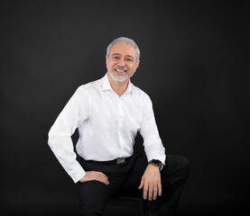 Portrait confident smiling casual middle eastern caucasian business man in white shirt sitting on stool  - 710286749