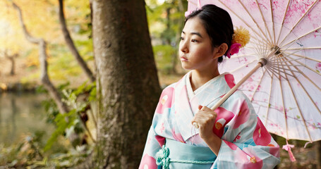 Thinking, traditional and Japanese woman in park for wellness, fresh air and relax with umbrella outdoors. Travel, culture and person in indigenous clothes, style and kimono for peace in nature