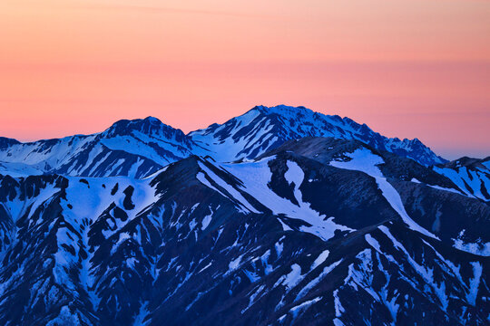 夕焼けの冠雪の北アルプスの立山連峰