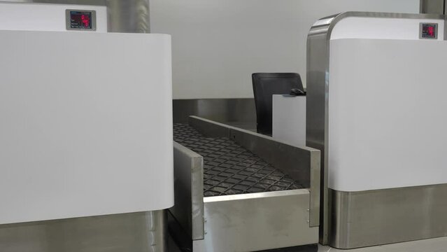 Woman lifting her backpack at an airport security checkpoint with a digital weight display