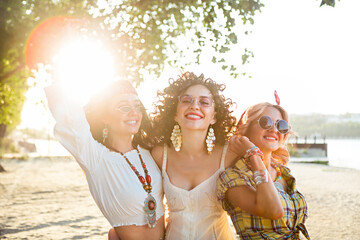 Naklejka premium Happy slim tan women on the beach in sunset. Travel and happiness concept