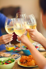 Hands of a group of people cheering with white wine