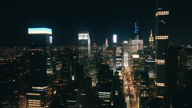 Skyscrapers finance district. Aerial flight over NYC downtown illuminated at night. Night traffic aerial.Big Apple cityscape at night drone shot. New York city night evening buildings downtown skyline