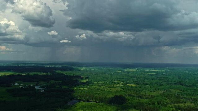 Aerial view of a lush landscape under the dramatic sky of an approaching storm