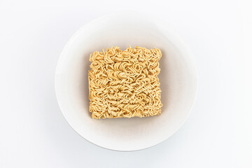 Instant noodle in white plate on white background, top view.