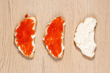 Sandwiches with red caviar. A delicious appetizer of trout caviar on a slice of bread with cream...