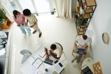 Managers, developers and designers working on mobile application in office, top view