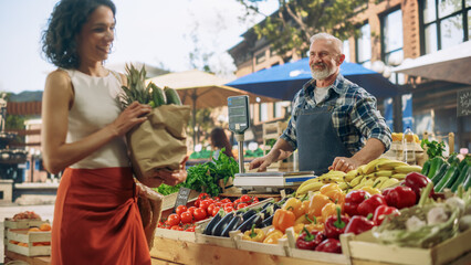 Portrait of a Happy Senior Street Vendor Packing a Paper Bag with Fresh Organic Vegetables for a...