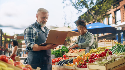Local Farmers Managing a Family Business, Offering Sustainable Farm Products for Sale. Portrait of a Middle Aged Male Using Laptop Computer to Manage Inventory and Online Orders of Organic Produce
