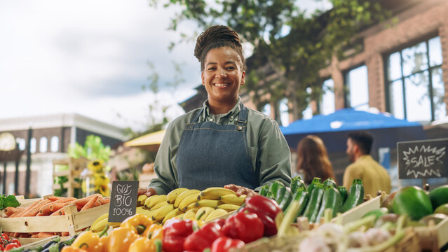 Portrait of a Multiethnic Middle Aged Female Managing a Street Vendor Food Stand with Fresh Organic Agricultural Products. Happy Stylish African Farmer is Looking at Camera and Charmingly Smiling