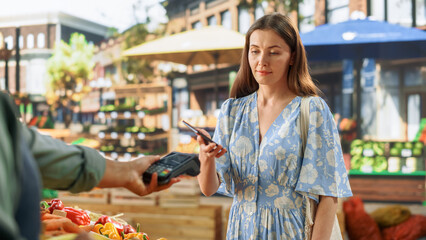 Stylish Young Woman Using Smartphone with Contactless NFC Payment Technology to Buy Organic...