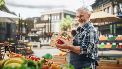 Middle Aged Male Farmer Managing a Small Business on an Outdoors Farmers Market, Selling...