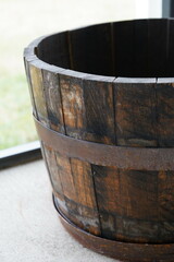 Antique wooden barrel placed on a rustic porch, near a window
