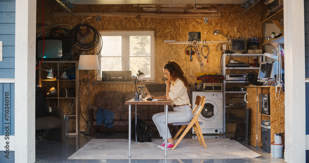 Aufkleber hispanic female software engineer programming on laptop computer in garage at home. focused young wo