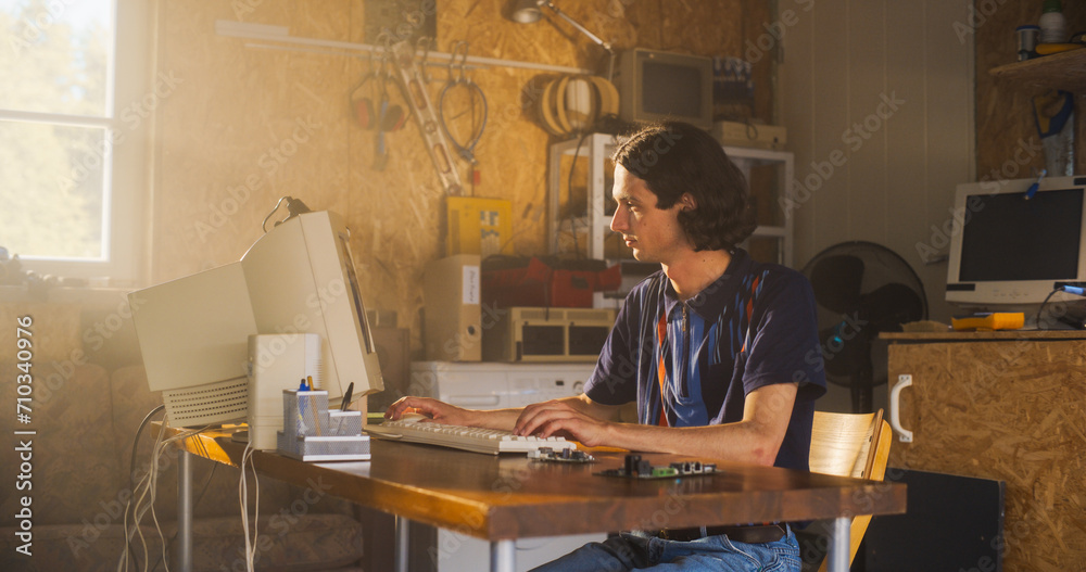 Poster Caucasian Male Computer Engineer Coding On Old Desktop PC And Inspecting Microchip In Retro Garage. Man Starting an Innovative Computer Company In Nineties, Building New Devices. Nostalgia Concept.